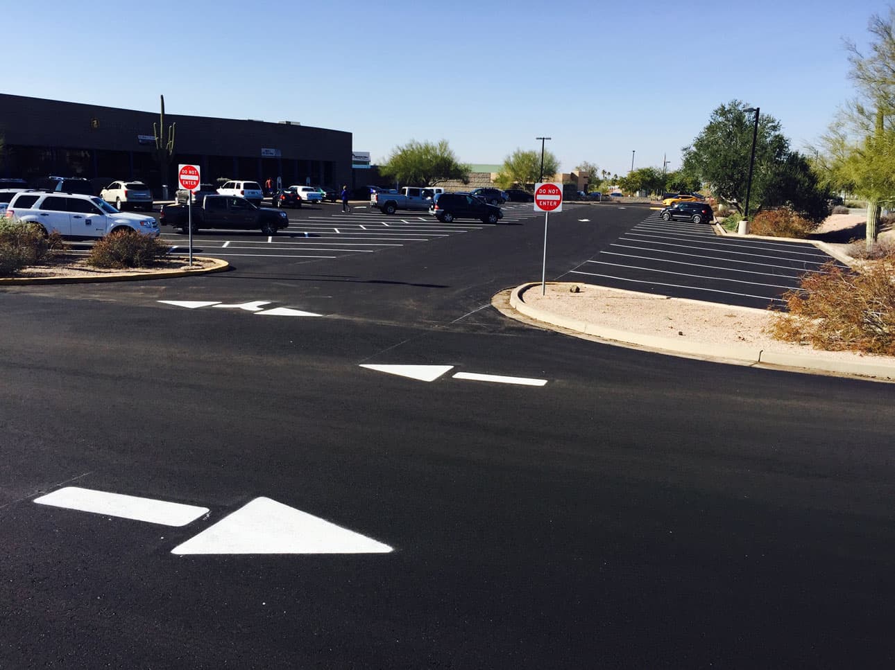 Completed commercial parking lot with new striping and directional arrows