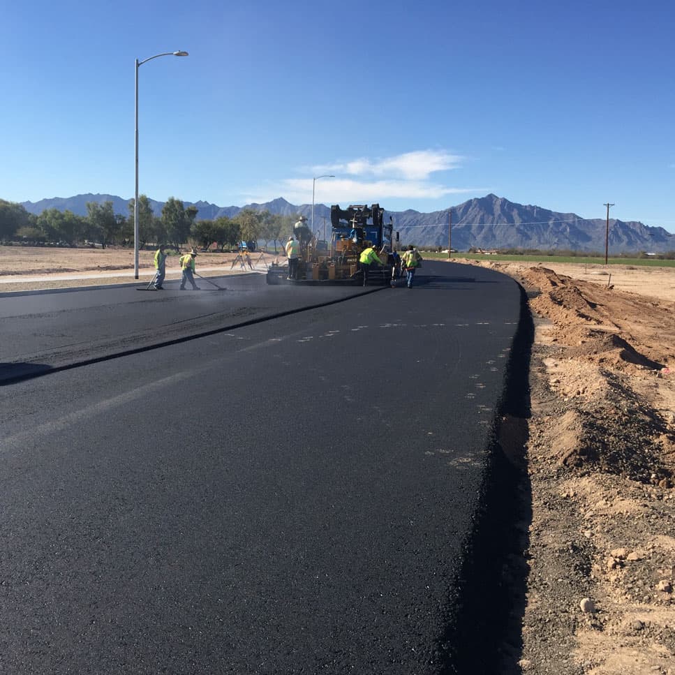 Fresh asphalt roadway paving with Arizona mountains in the background