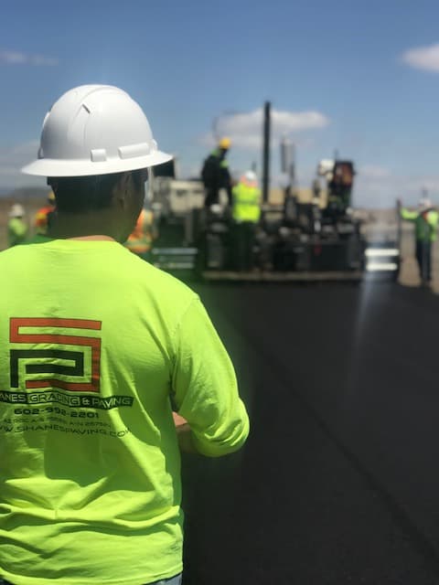 Shane’s Grading and Paving crew member on-site during a paving job